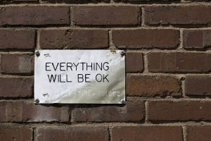 Metal sign on brick with Everything Will Be Okay written on it