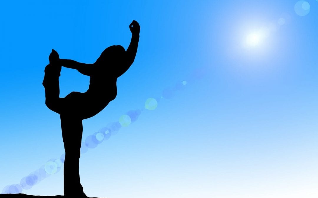 Silhouette of woman doing yoga on blue sky background