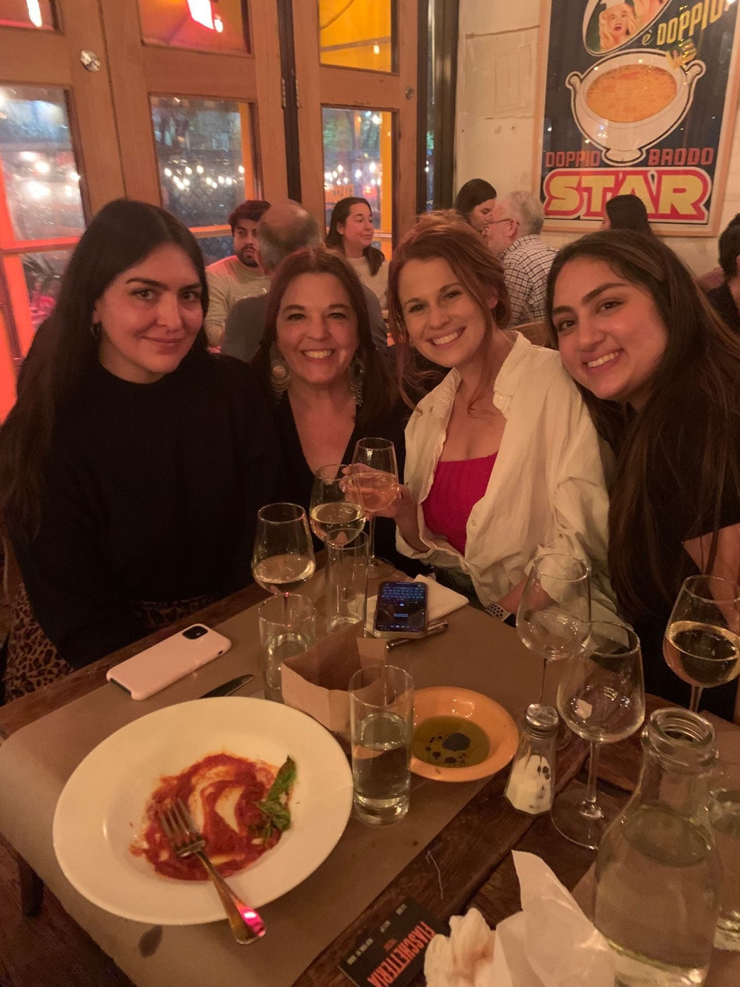 four women smiling at a dinner table
