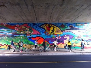 Bikers (potential customers), looking at a mural on the BeltLine path (click for source)