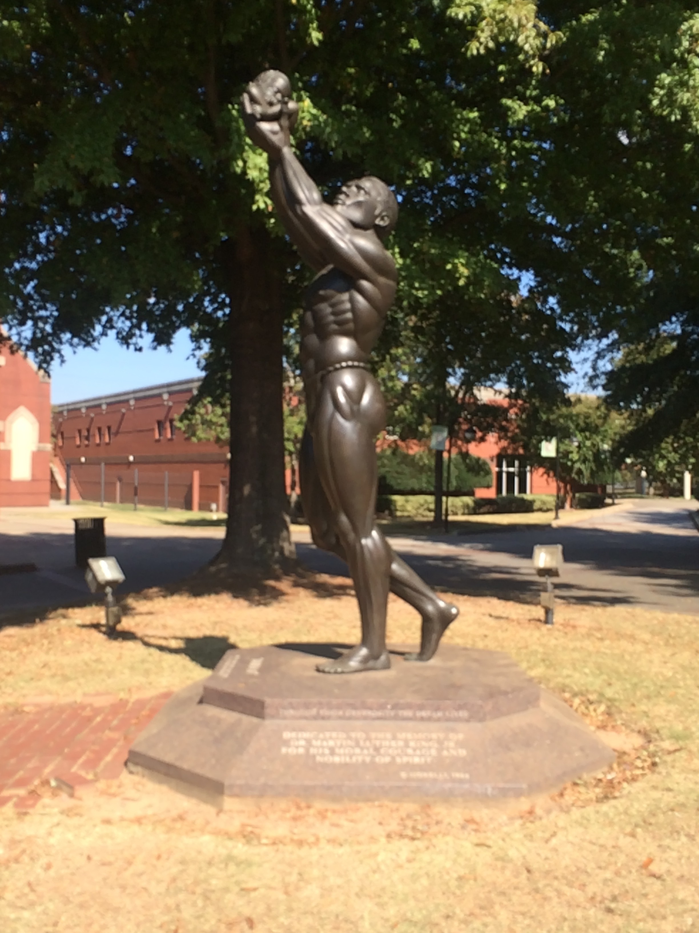 This is an image of the statue outside of the King National Historic Site. It is called "Behold" and is dedicated to the memory of Dr. Martin Luther King Jr. for his moral courage and nobility of spirit. It depicts the baptism of the infant Izzy by her father Kunte Kinte. 